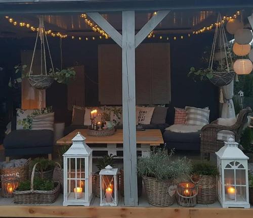 a patio with lanterns and a table with candles at Dom Skandynawski Sen in Wałcz