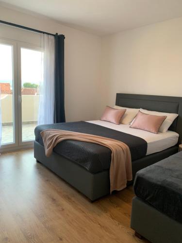 a bedroom with a large bed with pink pillows at Merita Apartments with Pool in Sveti Filip i Jakov