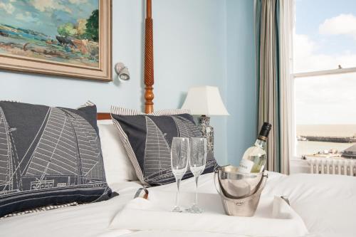 a bed with two wine glasses and a lamp at The Royal Harbour Hotel in Ramsgate