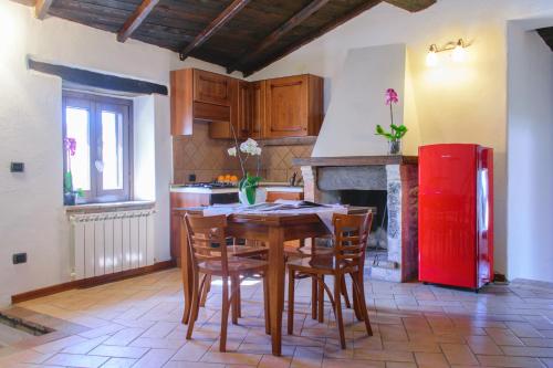 a kitchen with a wooden table and a red refrigerator at Borgo San Valentino in Arrone