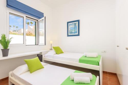 una habitación con dos camas y una ventana en Villa Cal Peixito, en Son Bou