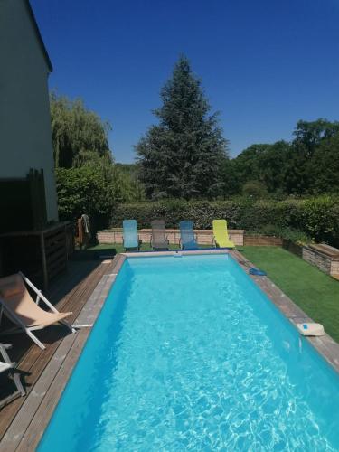 - une piscine avec des chaises sur une terrasse en bois dans l'établissement CHALET DU LAC PISCINE à 5 MINUTES DE DISNEY TGV RER, à Montévrain