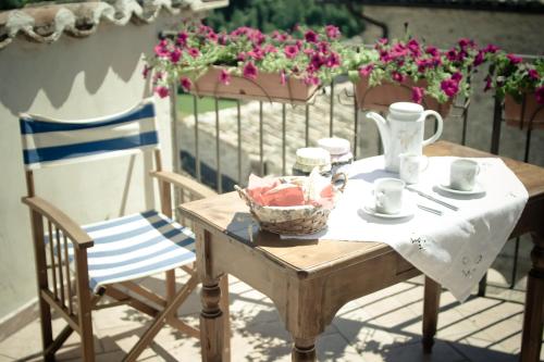 a table and a chair on a patio with flowers at Borgo San Valentino in Arrone