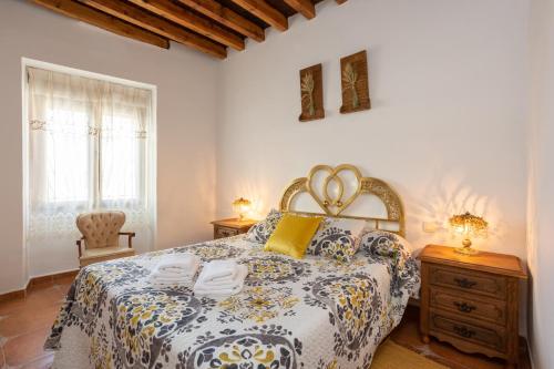 a bedroom with a bed and a dresser and a window at Casa Rural Almenas del Cid in Almonacid de Toledo