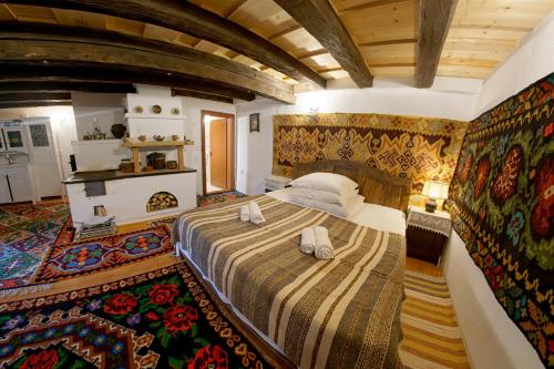 バマにあるCasa Povestilor din Bucovinaのベッドルーム1室(大型ベッド1台付)