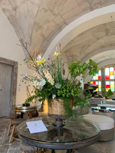 a vase of flowers sitting on a glass table at Palazzo Castriota in Alezio
