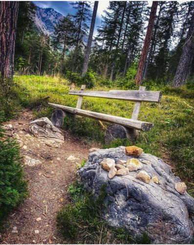 a wooden bench sitting on top of a rock next to a rock at Gästehaus Karl August in Fohnsdorf