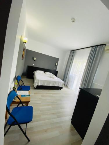 a bedroom with a bed and a desk and chairs at Blue Wave in Mamaia Sat/Năvodari