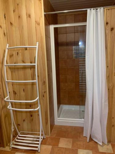 La salle de bains est pourvue d'une douche et d'un rideau de douche blanc. dans l'établissement Studio indépendant tout confort pour 4 personnes 25 m carrés, à Lapalme