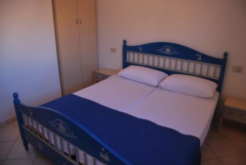 a bedroom with a blue and white bed with two pillows at Acquasmeralda appartamento 01 in Rosolina Mare