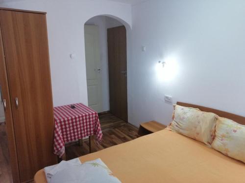 a small room with a bed and a table with a table at vila elly in Piatra Neamţ