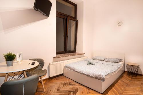 a bedroom with a bed and a table with chairs at Dream Aparts - Rewolucji 1905r in Łódź