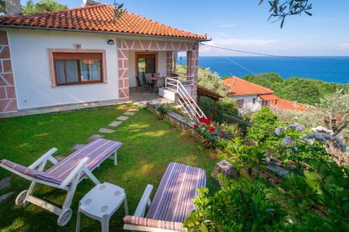 a small house with a yard with a table and chairs at Gardenia Sea View Home in Chorefto