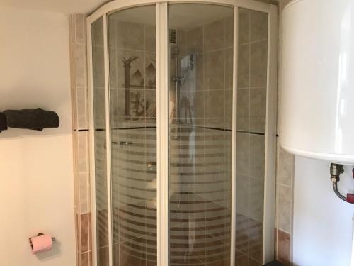 eine Dusche mit Glastüren im Bad in der Unterkunft Les Appartements de St-Etienne in Fécamp