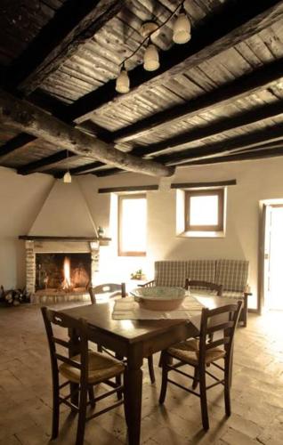 a living room with a table and chairs and a fireplace at Borgo San Valentino in Arrone
