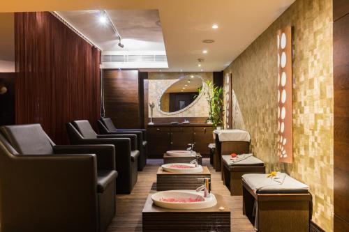 a waiting room with chairs and tables and a mirror at The Landmark Towers in Kānpur