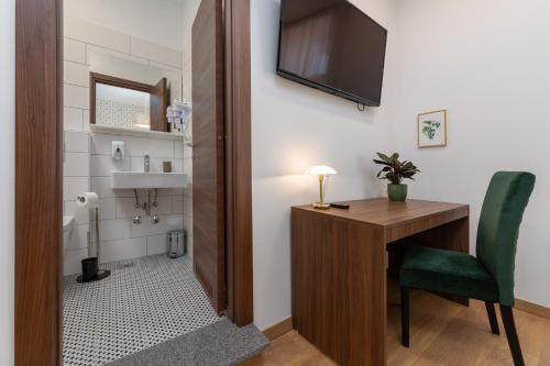 ein Badezimmer mit einem Schreibtisch, einem Waschbecken, einem Schreibtisch und einem Stuhl in der Unterkunft Aurora Rooms B&B Pula in Pula