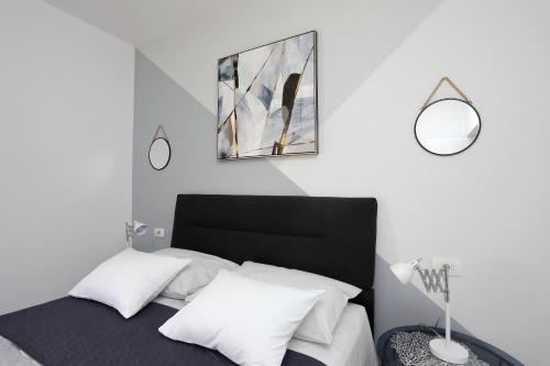 a bedroom with a black and white bed with two mirrors at Apartmani Marta in Sukošan