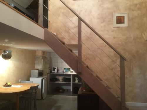 eine Treppe in einem Zimmer mit einem Tisch und einer Küche in der Unterkunft La Tour de Gué in Mirebeau
