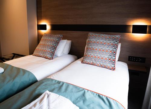a bed with two pillows and two nightstands at Oxford Hotel in London