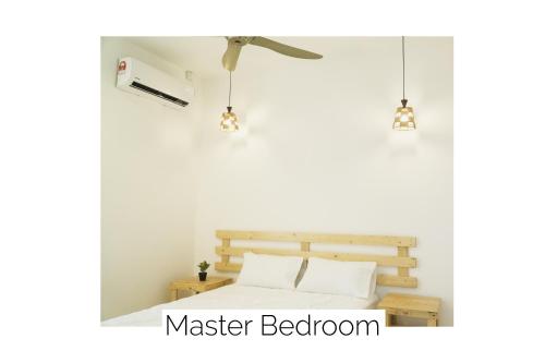 a bedroom with a bed and two pendant lights at Cozy, Modern, Air Cond Gambang Water Park Homestay -- The Pigeon Guest House in Kampong Pohoi