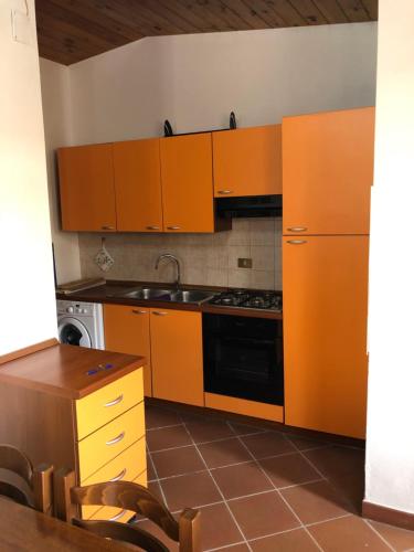 a kitchen with orange cabinets and a stove top oven at Casetta Mondello in Mondello