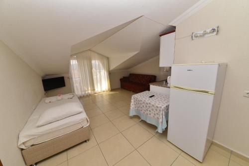 a small room with a refrigerator and a table at Mut Apart Hotel in Fethiye