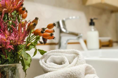 a bathroom counter with a vase of flowers and a towel at Villa Recla in Ronzone