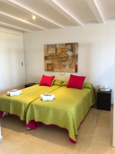 een slaapkamer met een groot geel bed met rode kussens bij Estudio Lala conil in Conil de la Frontera