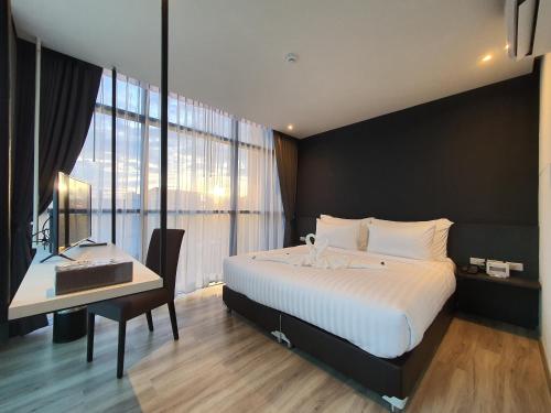 a hotel room with a bed and a desk and a bed and window at GOOD DREAM PREMIER in Hat Yai