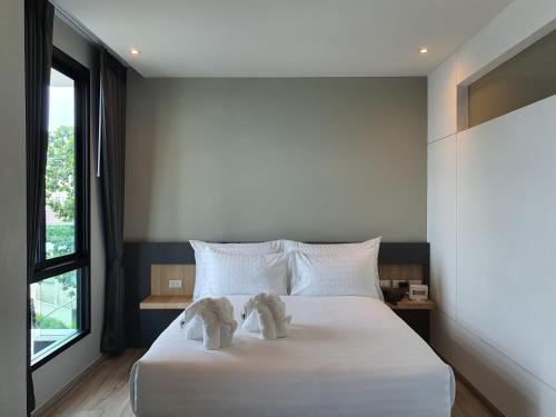 a bedroom with two elephants on a white bed at GOOD DREAM PREMIER in Hat Yai