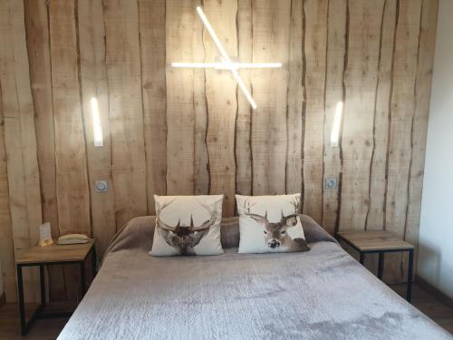 a bedroom with a bed with two deer pillows at Hôtel Yaka in Les Angles
