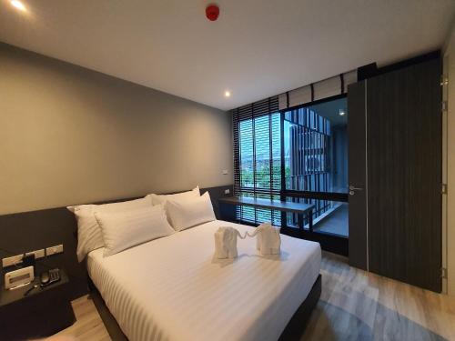 a bedroom with a bed with two towels on it at GOOD DREAM PREMIER in Hat Yai