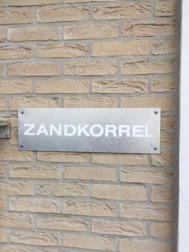 a sign on the side of a brick wall at De Zandkorrel in Westende