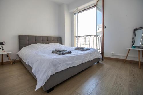 1 dormitorio con cama y ventana grande en ++++ renovated cosy 50m2 sunny flat / balcony / close to beach and to the Palais des festivals ++++, en Cannes