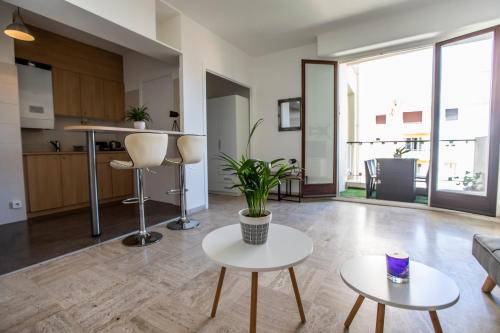 un salon avec deux tables et une cuisine dans l'établissement ++++ renovated cosy 50m2 sunny flat / balcony / close to beach and to the Palais des festivals ++++, à Cannes