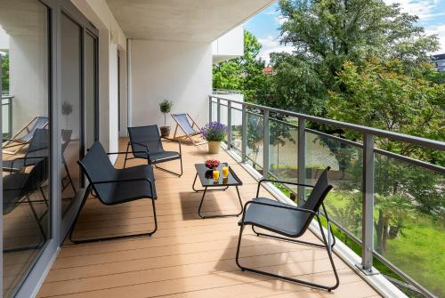 a balcony with chairs and a table with a view at apartamenty-wroc River Point in Wrocław