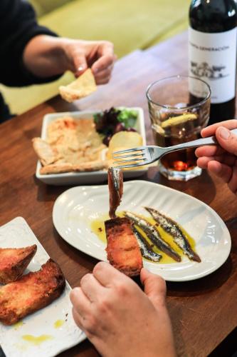 a table with a plate of food with meat on it at Hotel & Restaurant Marina Palamós in Palamós
