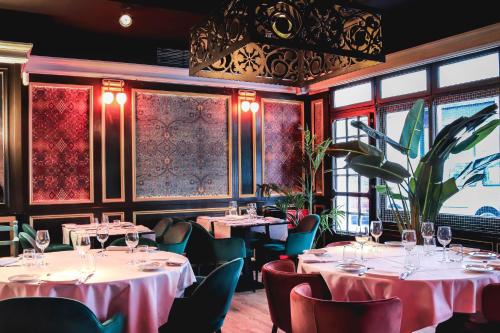 um restaurante com mesas, cadeiras e janelas em Hotel & Restaurant Marina Palamós em Palamós