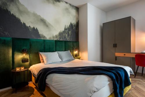 a bedroom with a large bed with a painting on the wall at apartamenty-wroc River Point in Wrocław