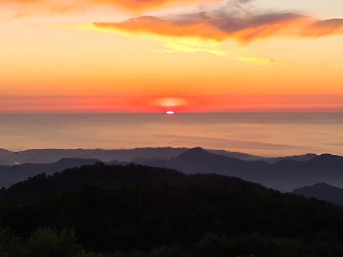 a sunset over a mountain range with the sun setting at Flora Handüzü Resort & Wellness Bungalow Hotel in Rize