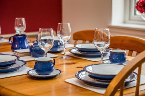 
a table topped with glasses and plates of food at Tigh Eilidh Cottage in St. Andrews
