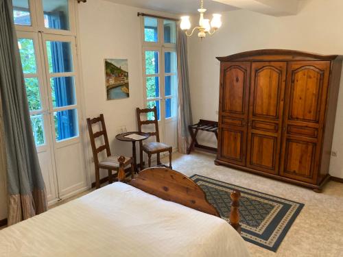 een slaapkamer met een bed en een houten kast bij Poppys Chambres d'Hotes in Céret