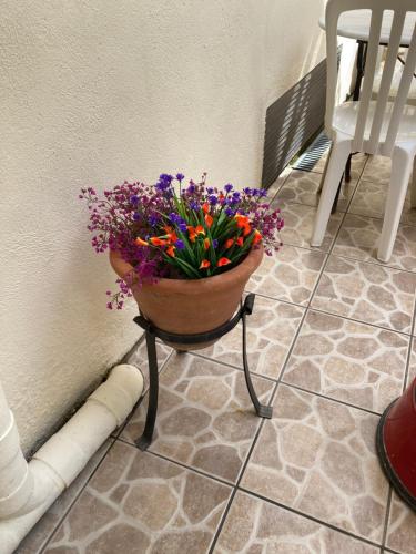 a pot of flowers sitting on a stand next to a wall at Poppys Chambres d'Hotes in Céret