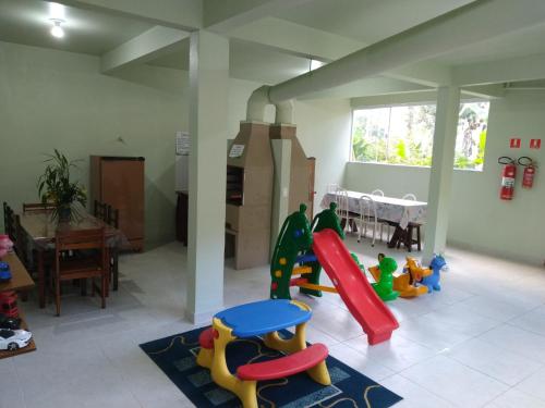 una sala de juegos con un tobogán y juguetes en Praialar Apartamentos Ubatuba, en Ubatuba