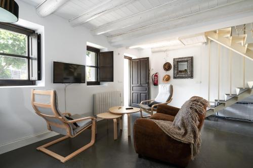 sala de estar con sofá, sillas y mesa en Casas Pirineos, en Sabiñánigo
