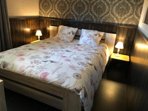 un letto in una camera da letto con due lampade sui tavoli di Mijn Kleinhof a Westouter