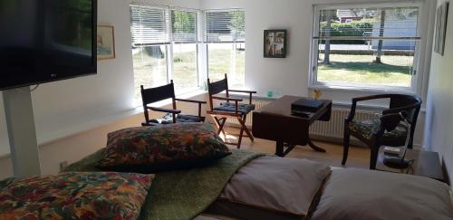 a living room with a couch and a table and chairs at Karens Bakke 2 in Glesborg