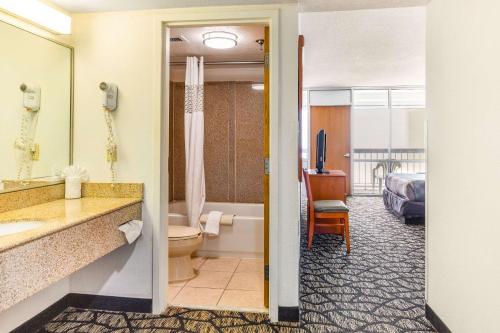 a hotel room with a bathroom with a tub and a bedroom at Seaview Hotel in Virginia Beach