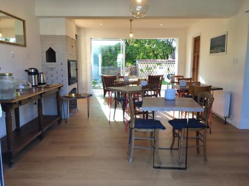 ein Restaurant mit Tischen und Stühlen in einem Zimmer in der Unterkunft Villa les Voiles - Chambres d'hôtes in Wimereux